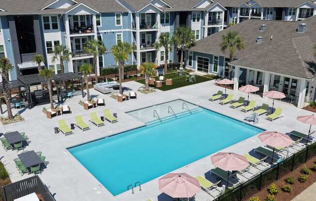 A large swimming pool surrounded by lounge chairs and umbrellas.