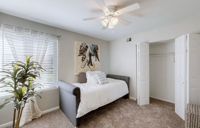 a bedroom with a bed and a ceiling fan