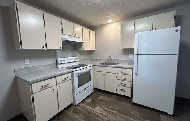 A kitchen with white appliances and cabinets.