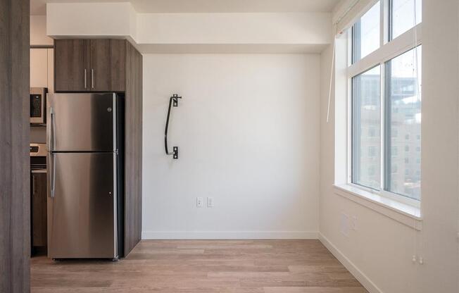 an empty room with a refrigerator and a window