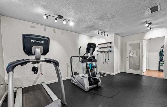A treadmill with a TRUFIT brand label is in a room with a TRUFIT brand wall hanging.