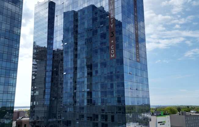 a tall blue building in the middle of a city