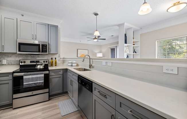 a large kitchen with white counter tops and stainless steel appliances
