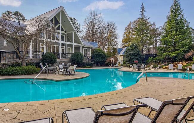 Swimming pool with lounge chairs with clubhouse in the background