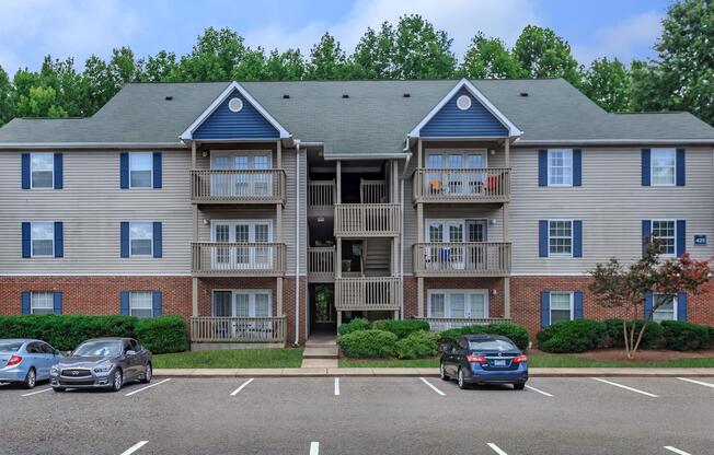 Apartment building exterior and parking lot at Ashley Oaks Apartments in Greensboro, North Carolina