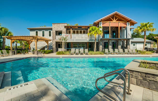 a swimming pool in front of a house with a pool