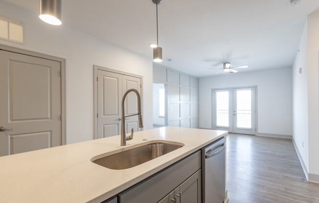 an empty kitchen with a sink and an empty living room