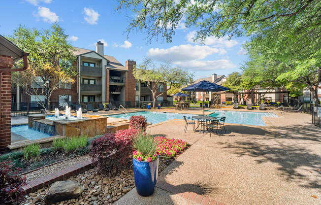A pool area with a blue vase in the foreground.
