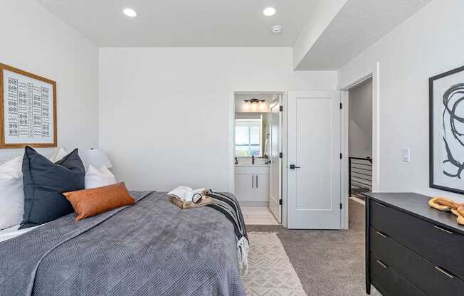 bedroom with a bed and dresser and a door leading to a bathroom