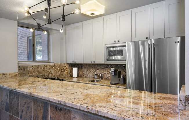 a kitchen with white cabinets and a granite counter top