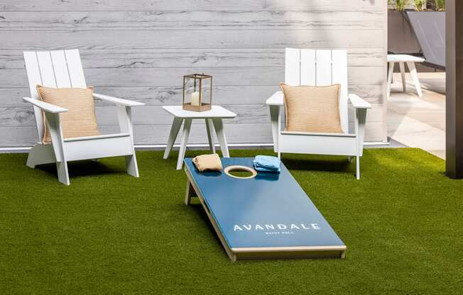 a group of white chairs around a coffee table on the grass