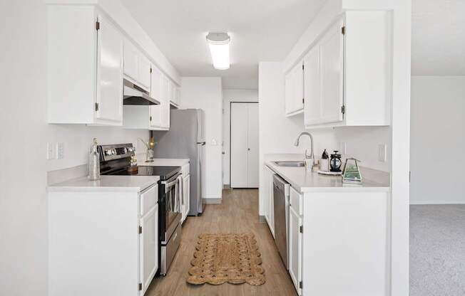 A kitchen with white cabinets and appliances.