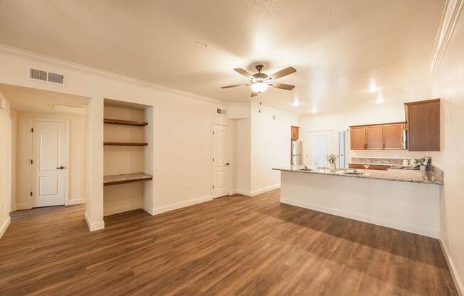 A room with a ceiling fan and wooden floors.