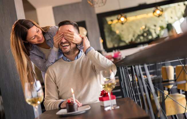 a woman covering a mans eyes in a restaurant at The Falls of Portofino, Naples, FL, 34119