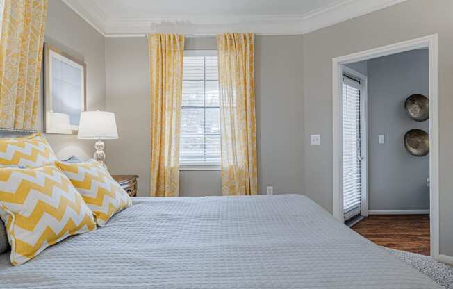 a bedroom with a large bed and yellow curtains