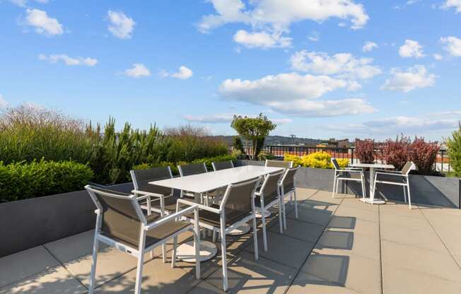 a patio with tables and chairs on the roof of a building