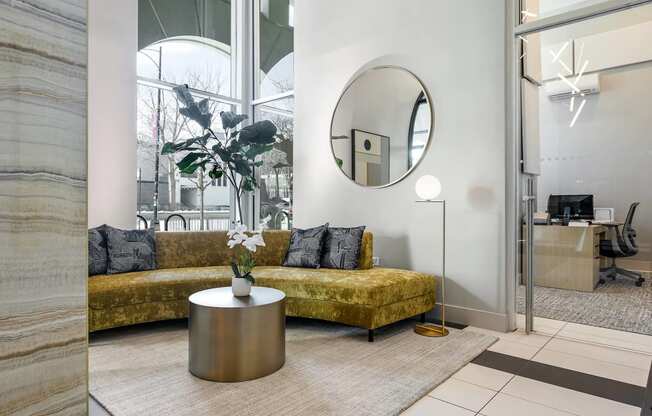 a living room with a couch and a round mirror