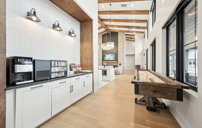 a long cafeteria with a long wooden table and a counter with coffee machines