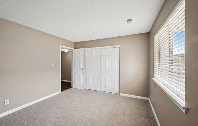 an empty living room with a large window and a white door