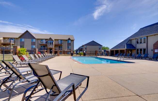 A sparkling outdoor pool at the clubhouse, with clear blue water and sun loungers, invites residents to relax, swim, and enjoy leisurely moments in a beautiful, serene setting.