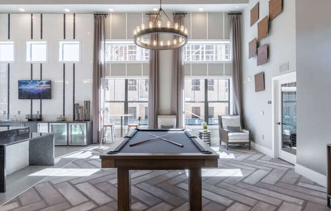 an open living room with a pool table and a large window