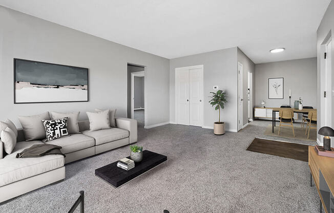 Model Living Room with Carpet and View of Dining Room at Stone Ends Apartments in Stoughton, MA.