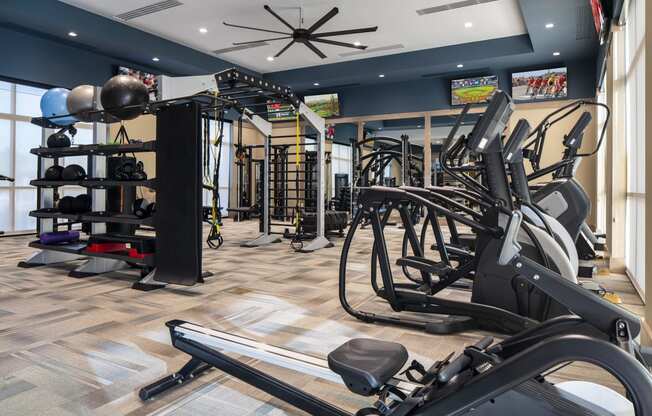a spacious fitness room with cardio equipment and weights