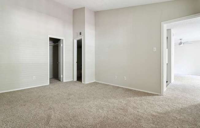 A room with a carpeted floor and two doors.