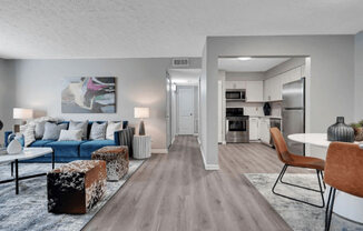 a living room with a couch table and chairs and a kitchen in the background at Enclave at Breckenridge Apartments, Louisville, KY, 40220