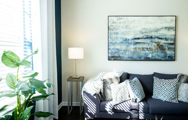 a living room with a couch and a painting on the wall