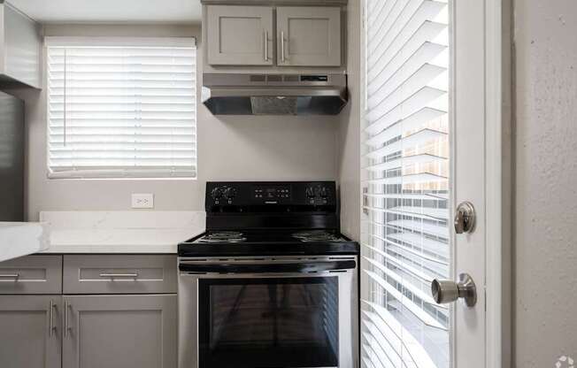 A modern kitchen with a black stove top oven.