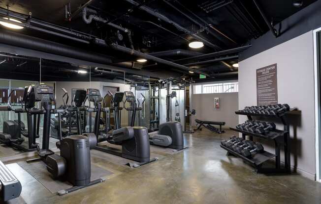 a view of the fitness center with cardio equipment on the left and weights on the right