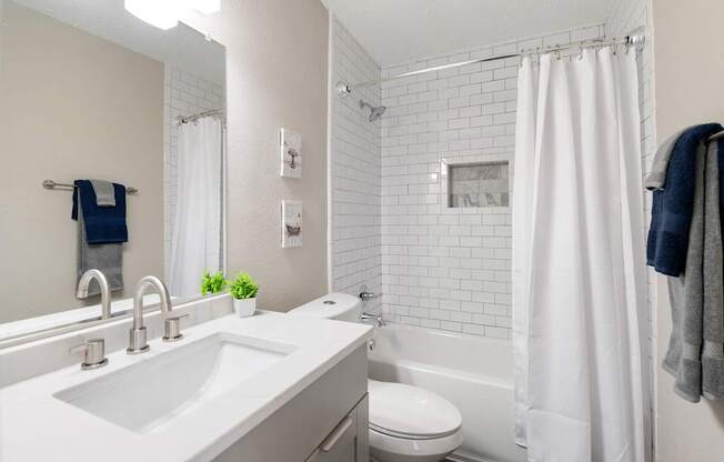 A white bathroom with a white sink and a white tub. at Mill House at East Cobb, Marietta, GA 30067