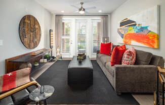 A spacious living room with floor to ceiling windows and a patio