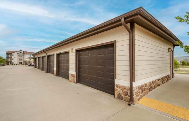 a row of garages in front of a building at Parc at Bentonville Apartments in Bentonville, AR