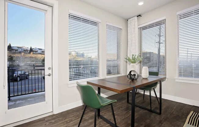 A room with a table and chairs and a view of a street outside.