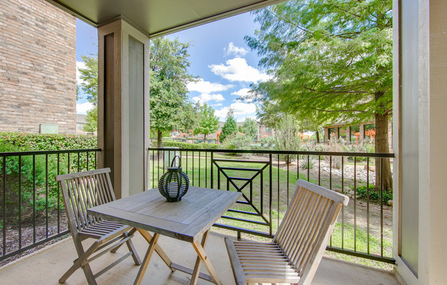 View of Private Patio, Showing Table and Chairs, Landscaping, and Community View at Enclave on Golden Triangle Apartments