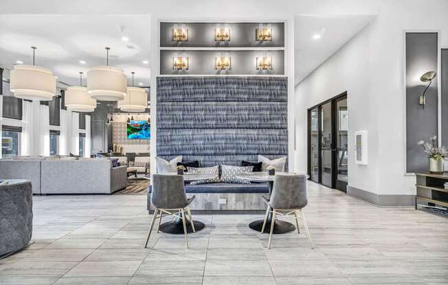 A modern living room with a grey sofa and two chairs.