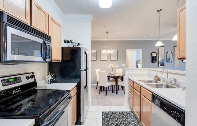 A kitchen with black appliances and wooden cabinets.