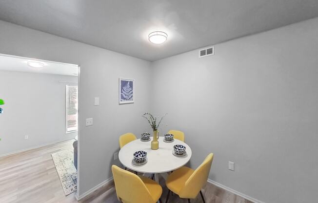 a dining room with a white table and yellow chairs