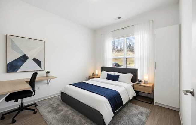 A bedroom with a bed, desk, and chair.