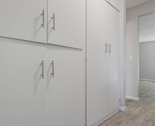 a row of white cabinets in the corner of a room at The Arches Apartments, El Cajon