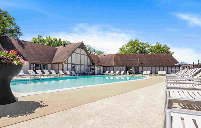 a swimming pool with chairs and a building in the background