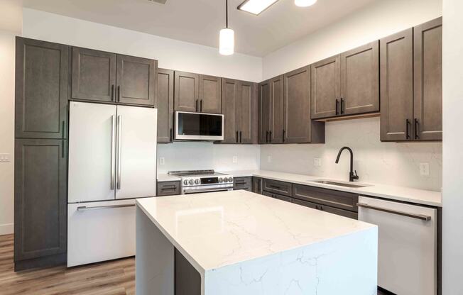 a kitchen with a large island and stainless steel appliances