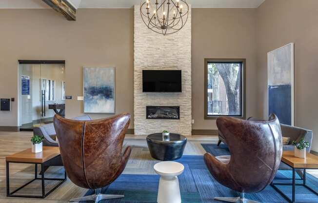 a living room with two leather chairs and a fireplace