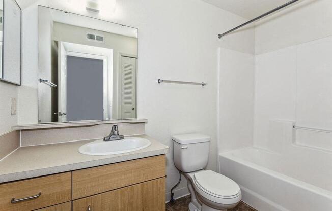 a bathroom with a sink toilet and a mirror at Fieldstream Apartment Homes, Iowa