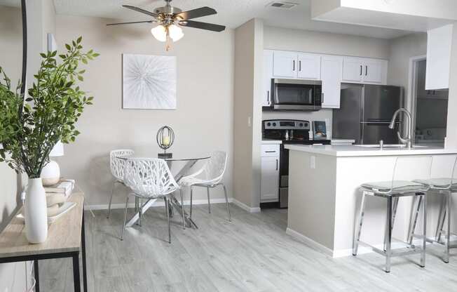 an open kitchen and living room with a dining room table and chairs and a kitchen