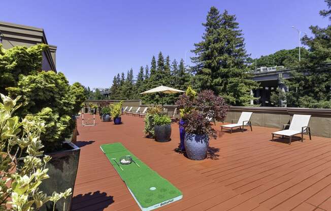a mini putting green on the resident rooftop deck with trees in the background at Illumina Apartment Homes, Seattle, Washington 98102
