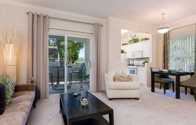 A living room with a couch, a chair, a coffee table, and a dining table.