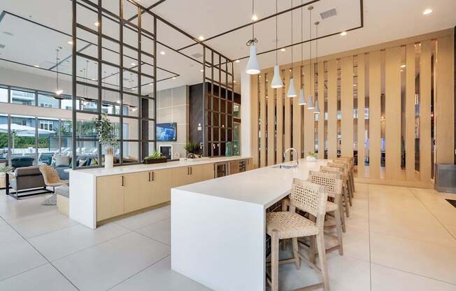 A modern kitchen with a white counter and chairs.